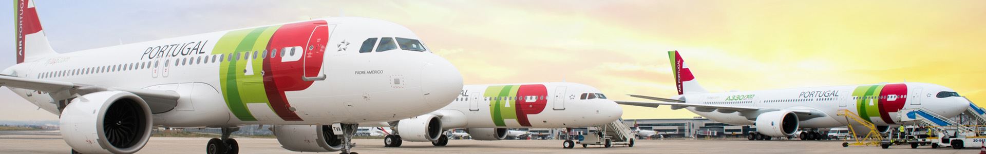 Photograph showing three planes arranged side by side, decorated with the colors and logo of TAP Air Portugal.